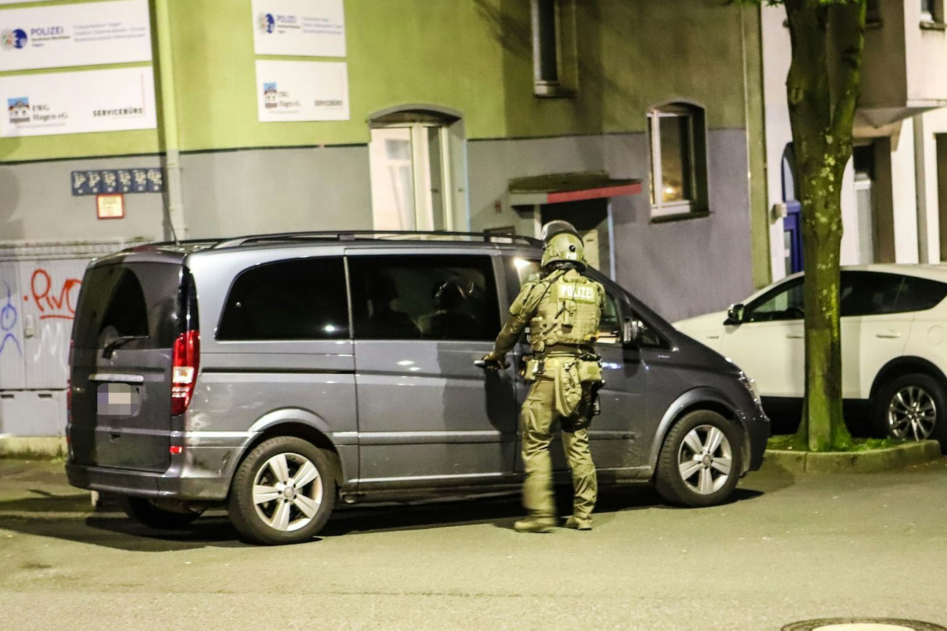 Ein Polizist steht während der Razzia an einem Van in Hagen. NRW war einer der Schwerpunkte des Einsatzes.
