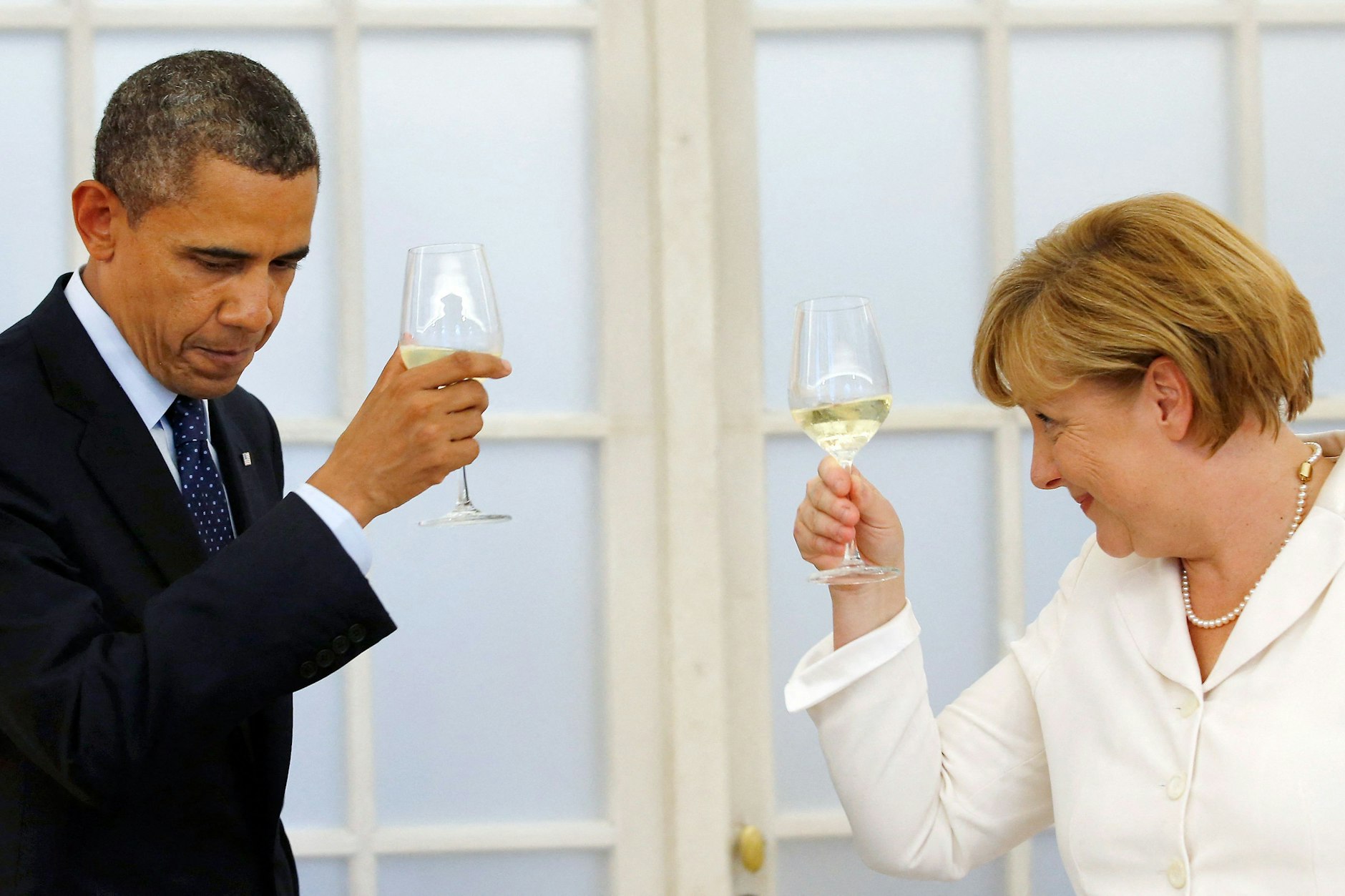 Barack Obama und Angela Merkel prosten sich zu. 