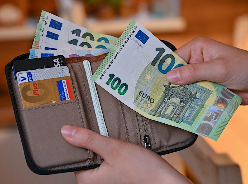 ARCHIV - Viele Eurobanknoten stecken in einer Geldbörse.  a/Illustration