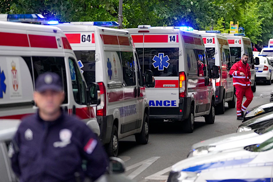 Die Polizei sperrt die Straßen um die Schule in Belgrad ab, Krankenwagen stehen bereit.