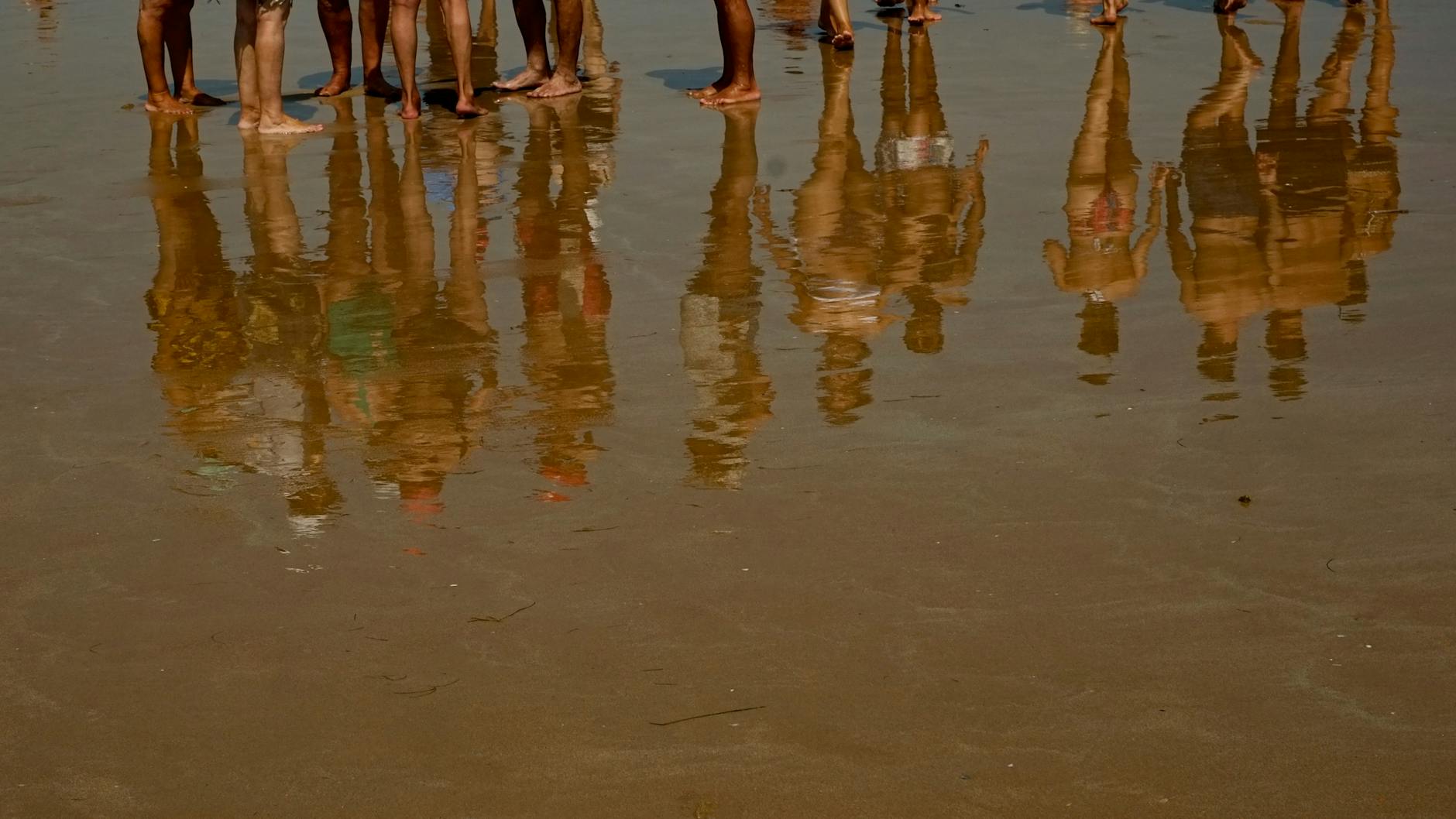 Menschen spazieren in Barcelona am Strand an einem heißen, sonnigen Tag.