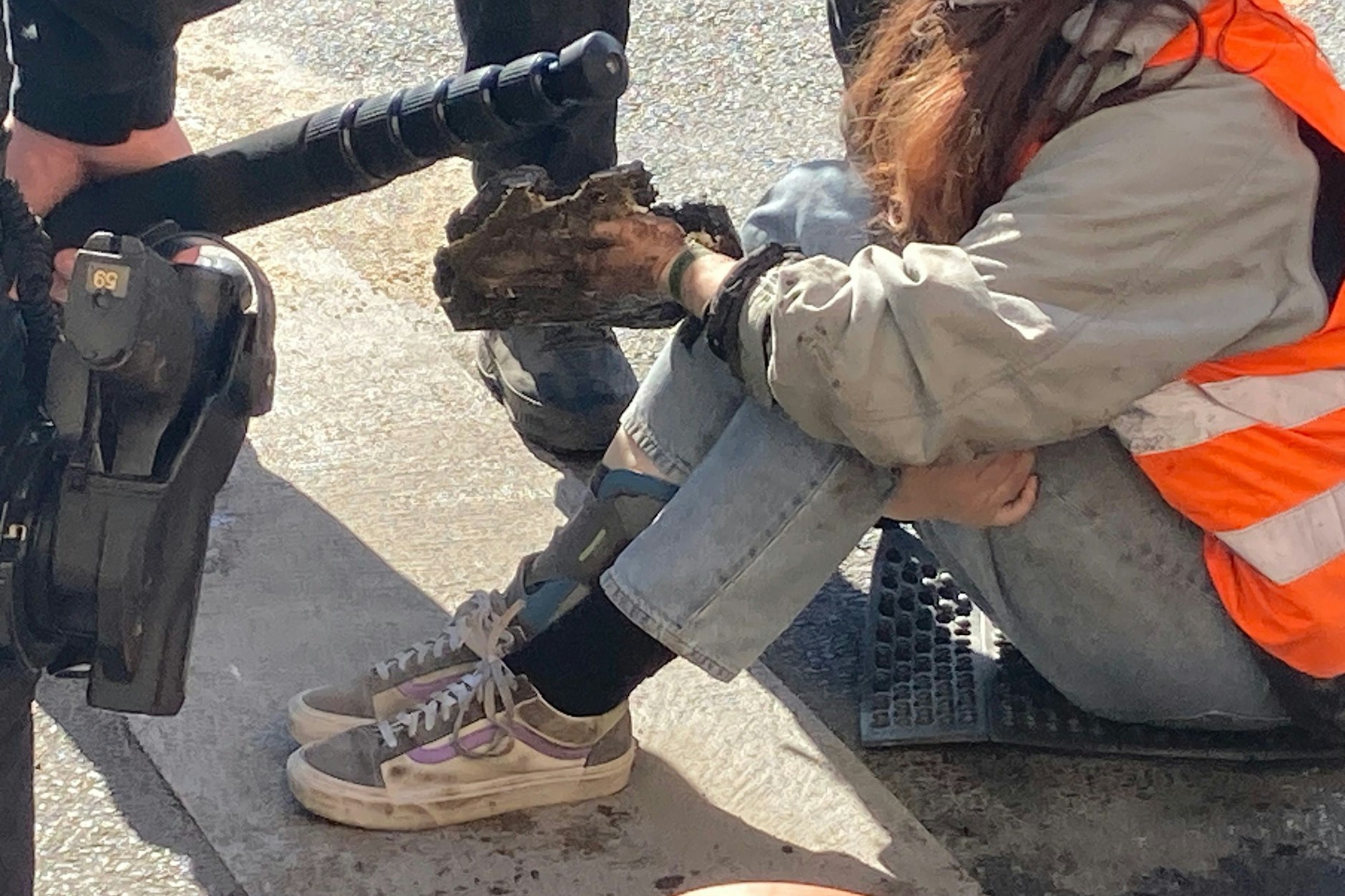 Aktivistin hat ein Stück Asphalt an der Hand, nachdem sie von der Straße geflext wurde.