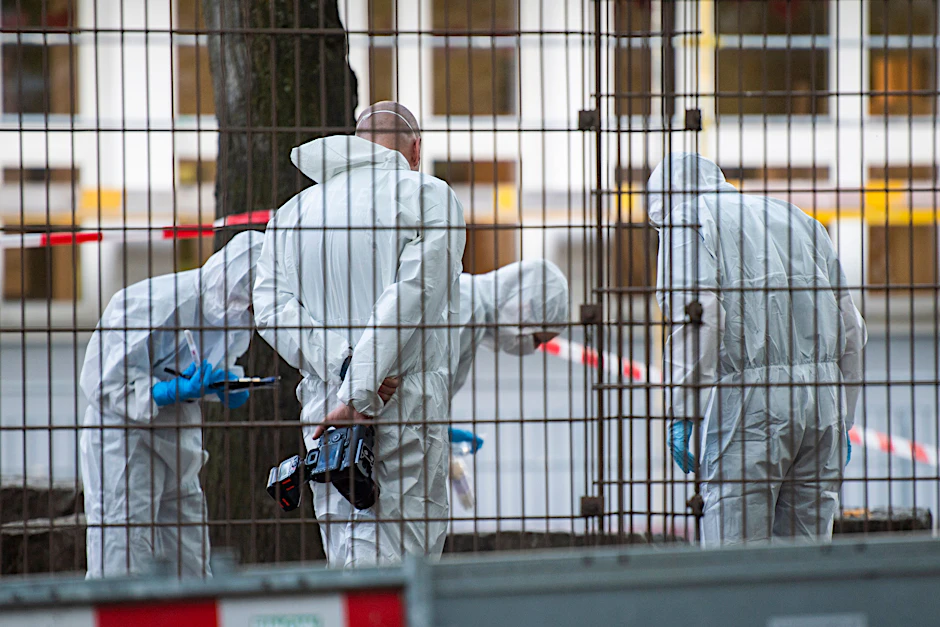 Mitarbeiter der Kriminaltechnik stehen in der Nähe der Schule in Neukölln.