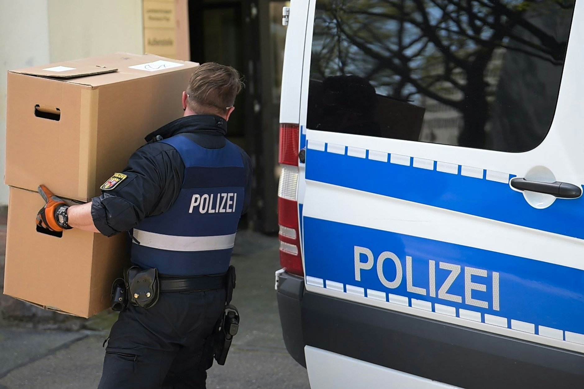Ein Polizeibeamter entlädt am Landeskriminalamt Rheinland-Pfalz einen Transporter mit sichergestelltem Material aus einer Razzia in mehreren Bundesländern gegen die italienische Mafia 'Ndrangheta.