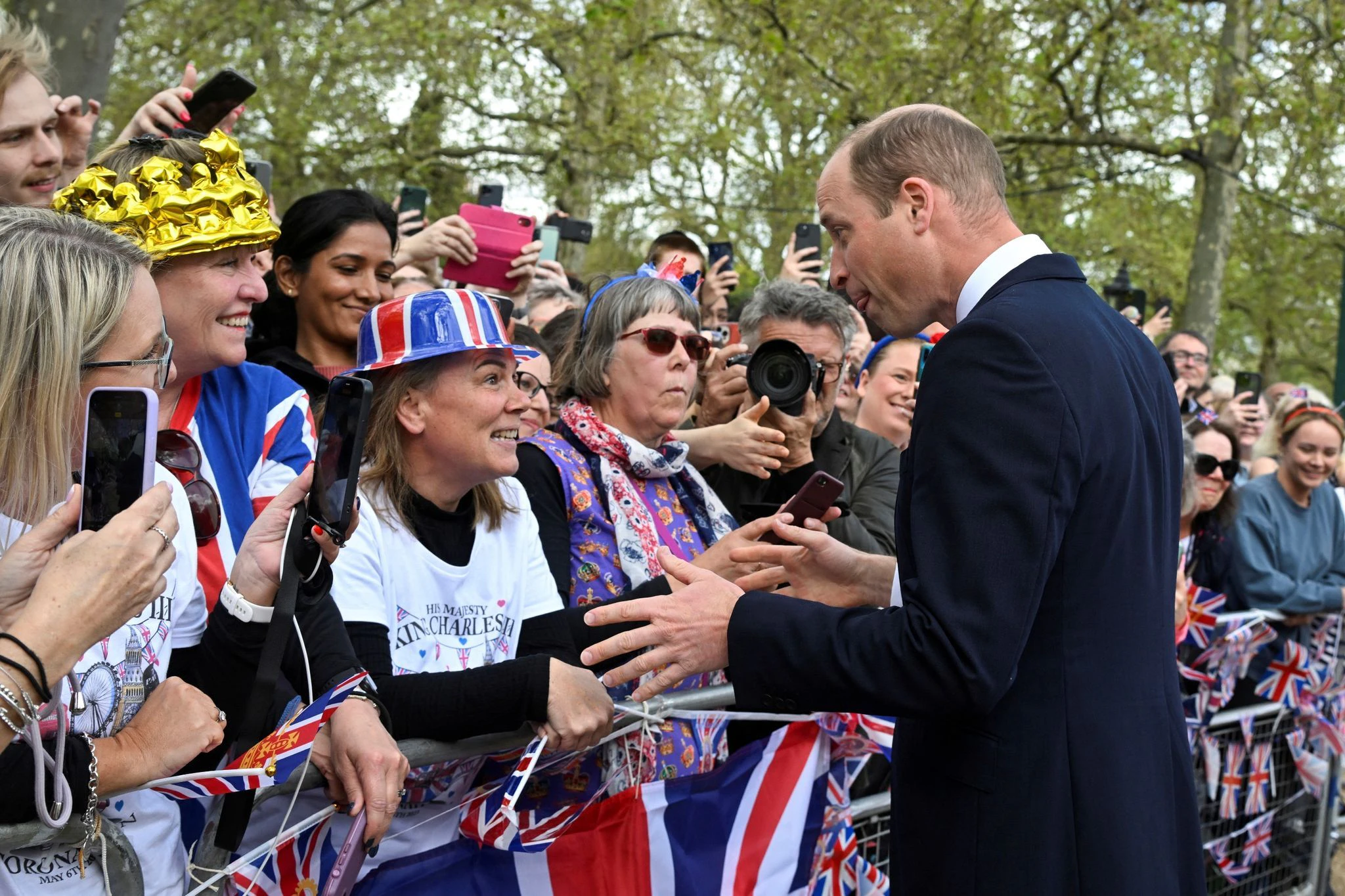 Prinz William (r.) begrüßt Gratulanten vor dem Buckingham Palace.