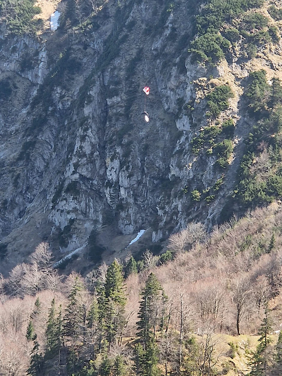 HANDOUT - Ein Gleitschirmflieger in den Seilen einer Seilbahn in Oberbayern - er konnte gerettet werden.  