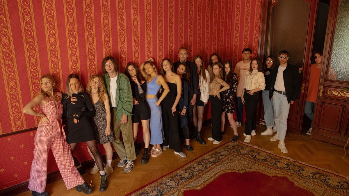 Künstlerinnen und Künstler aus der Ukraine leben und arbeiten in der Ukrainian Cultural Community (UCC) in Berlin. Für das Foto posieren sie in dem Wohnzimmer der Residenz. Diese befindet sich in einer Wohnung am Berliner Kurfürstendamm, die zuvor als Edelbordell genutzt worden war.