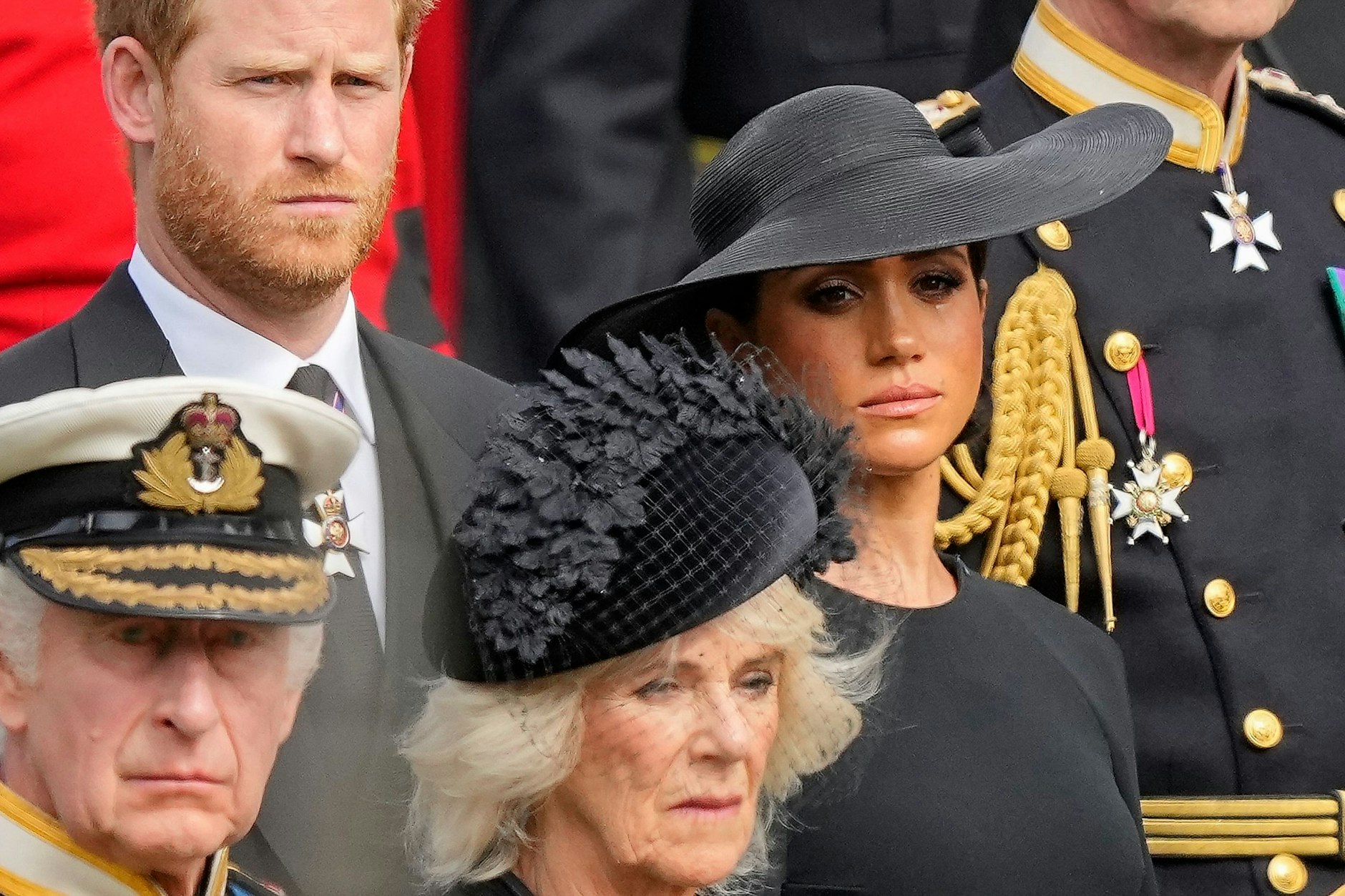 Prinz Harry (oben links) und seine Frau Meghan sind in der Royal Family nicht mehr wohlgelitten. Hier sind sie zusammen mit Charles und Camilla bei den Trauerfeierlichkeiten für Queen Elizabeth II. zu sehen.