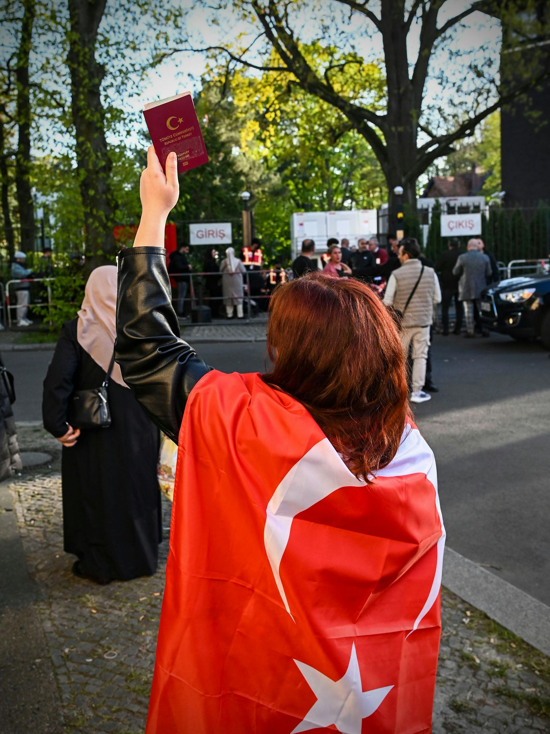 Viele Berliner mit türkischem Pass stehen in diesen Tagen Schlange, um zu wählen. Stolz zeigt Elif Pass und Flagge.