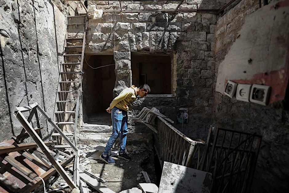 Ein Palästinenser inspiziert ein beschädigtes Haus nach einer Razzia der israelischen Streitkräfte.  