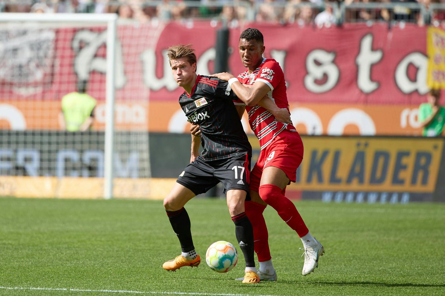 Unions Torjäger Kevin Behrens und Felix Uduokhai vom FC Augsburg im Zweikampf.