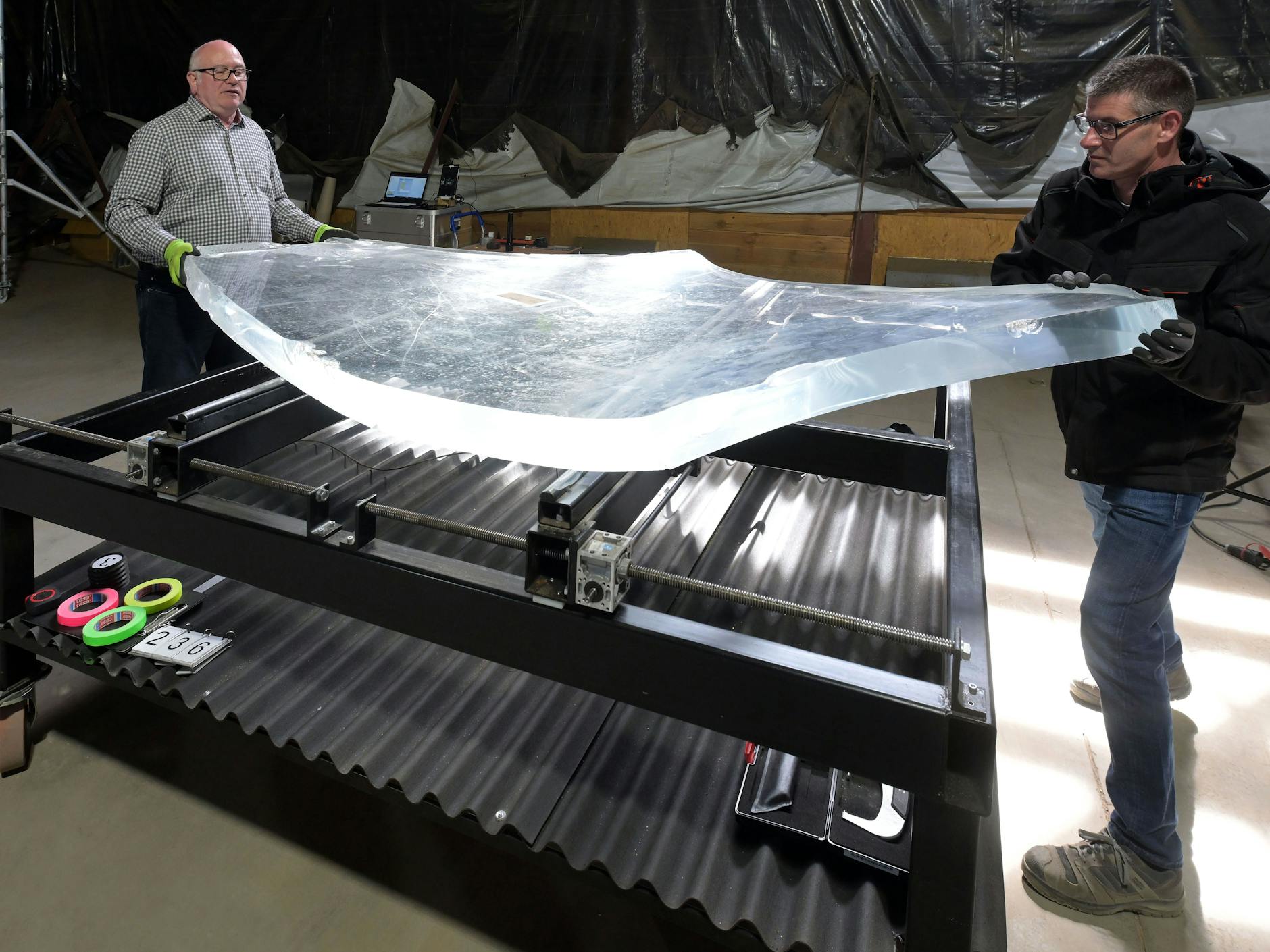 Der Materialprüfer Robert Kirchner (l.) und Helfer Frank Kettler wuchten ein Bruchstück in Position, damit es untersucht werden kann.