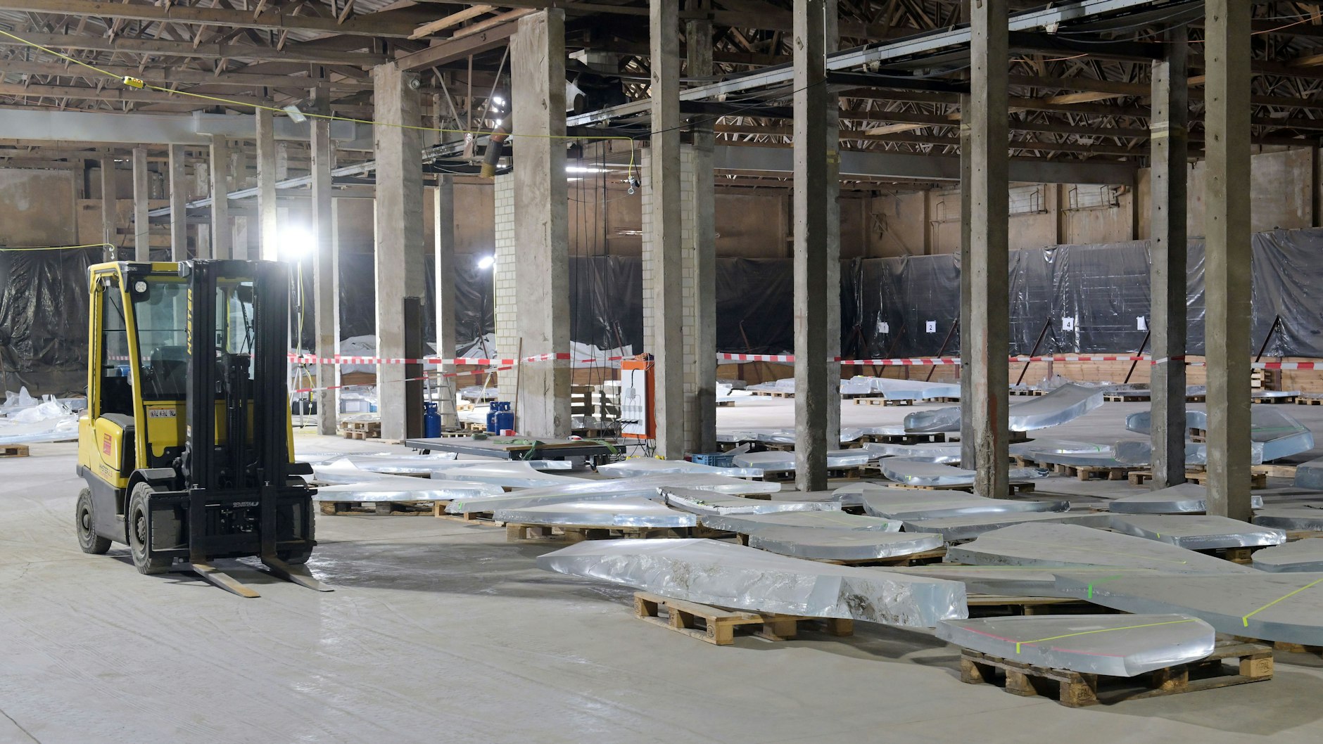Mit dem Gabelstapler werden die großen Bruchstücke bewegt, die auf Europaletten gelagert sind.