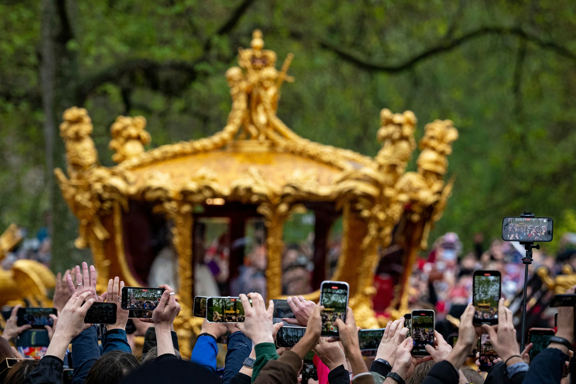 Menschen fotografieren die goldene Staatskutsche, die Charles und Camilla zurück zum Palast bringt.&nbsp;