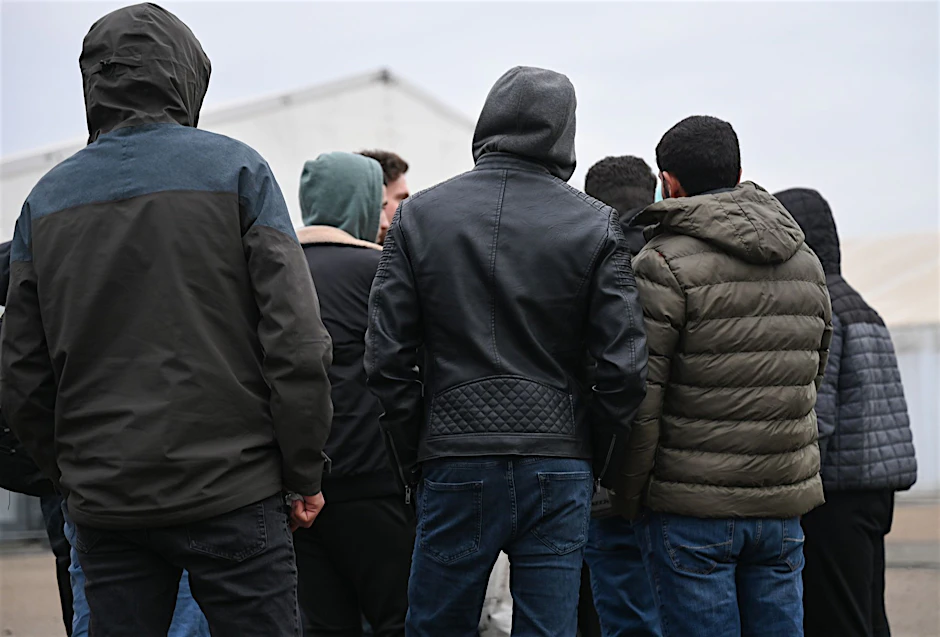 ARCHIV - Kriegsflüchtlinge aus Syrien stehen auf dem Gelände einer Flüchtlingsunterkunft zusammen.  
