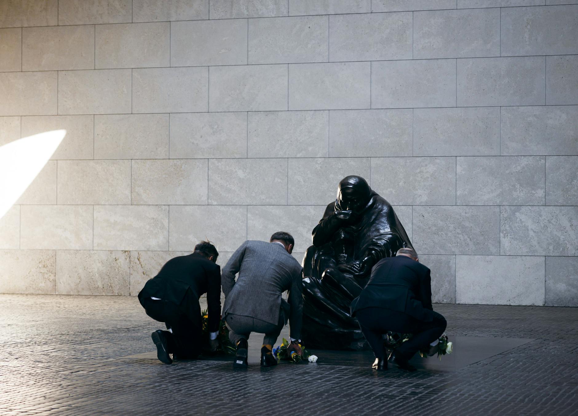 Tobias Lindner (l-r,), Staatsminister im Auswärtigen Amt, legt Blumen in der Neuen Wache in Berlin nieder. Er wird von Oleksij Makejew, dem ukrainischen Botschafter in Deutschland und dem Regierenden Bürgermeister von Berlin Kai Wegner (CDU) begleitet.