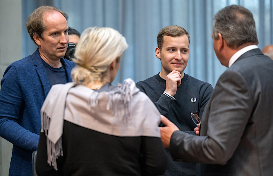 Marvin Müller (2.v.r) und Kai Gardeja (l.), Tourismusdirektor der Binzer Bucht, sprechen vor Beginn der Sitzung des Petitionsausschusses im Deutschen Bundestag zum umstrittenen LNG-Terminal auf Rügen mit den Bundestagsabgeordneten.