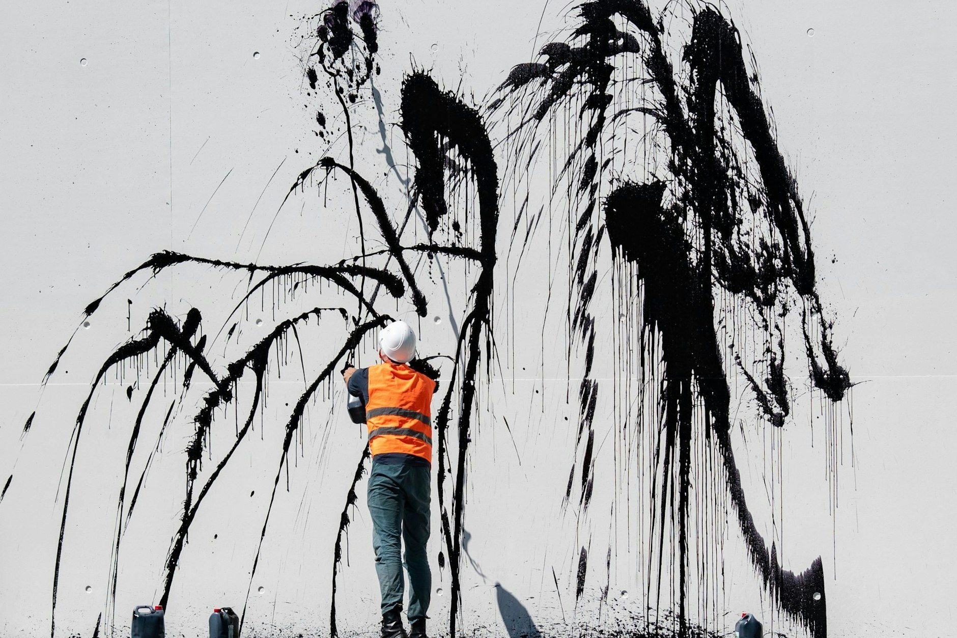 Klimaschutz-Demonstranten der Gruppe „Letzte Generation“ spritzen eine Flüssigkeit auf eine Fassade.