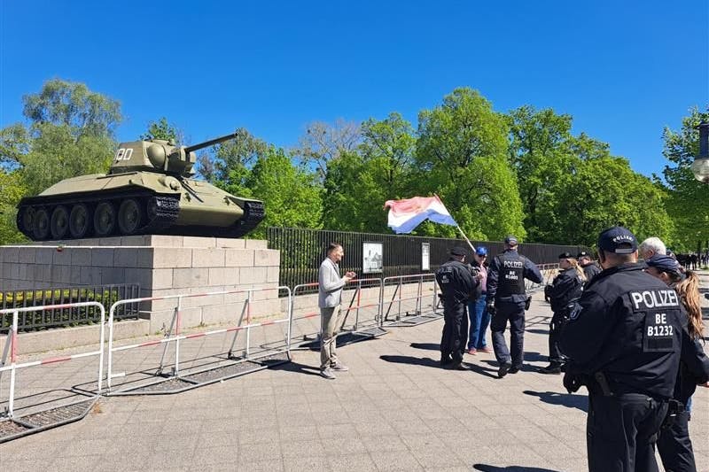 Ein Mann trägt eine Jugoslawien-Flagge.