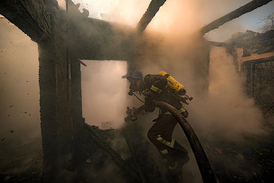 Ein ukrainischer Feuerwehrmann bei Löscharbeiten in einem nach russischen Angriffen zerstörten Haus in Kiew.&nbsp;