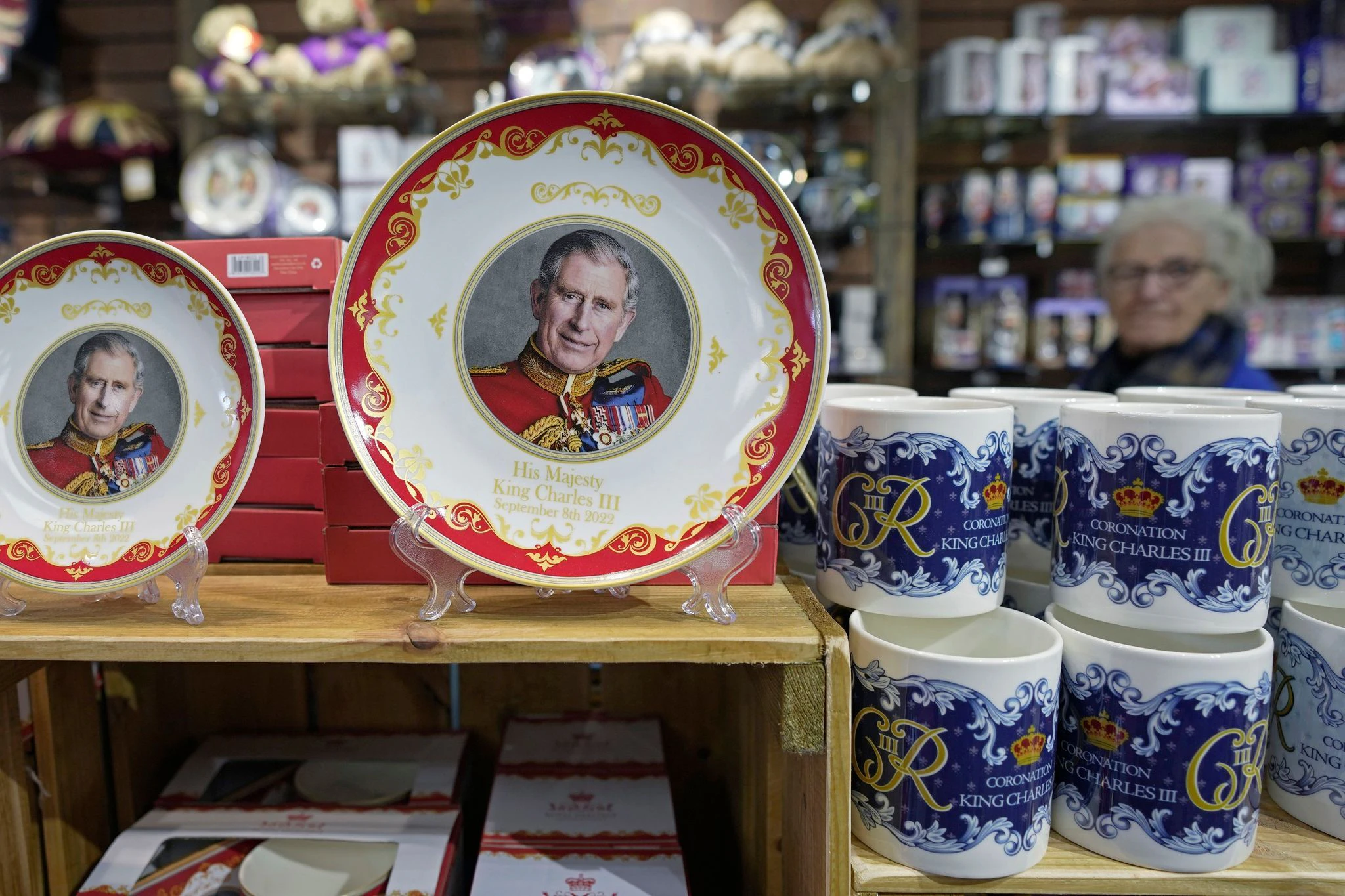 ARCHIV - Teller und Tassen zur Krönung von König Charles werden in einem Souvenirladen zum Verkauf angeboten.  