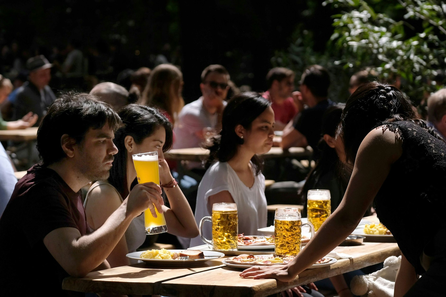 Gäste sitzen im Biergarten im&nbsp; Café am Neuen See.