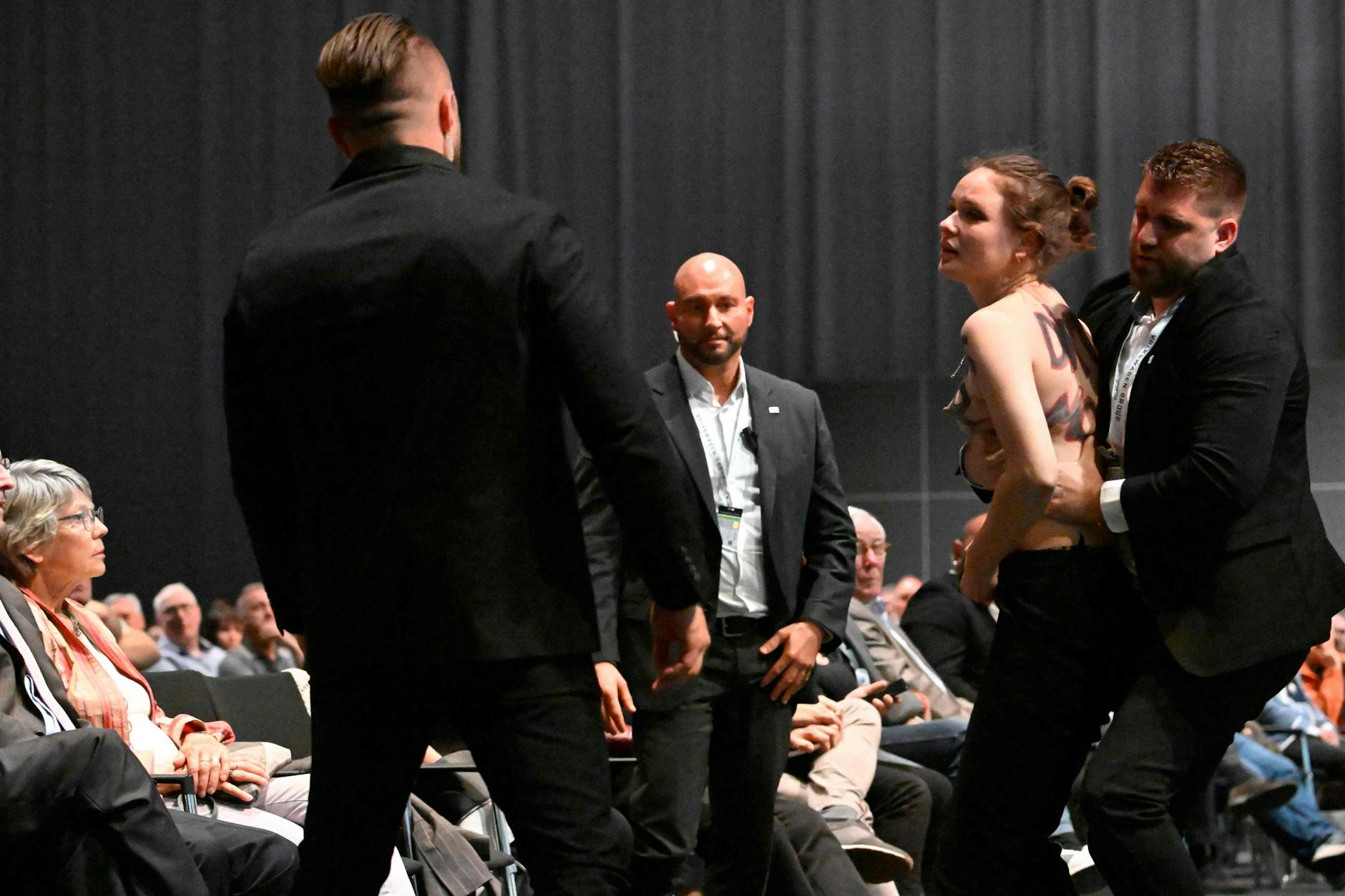 Eine Aktivistin protestiert mit nackten Brüsten auf der VW-Hauptversammlung in Berlin. 