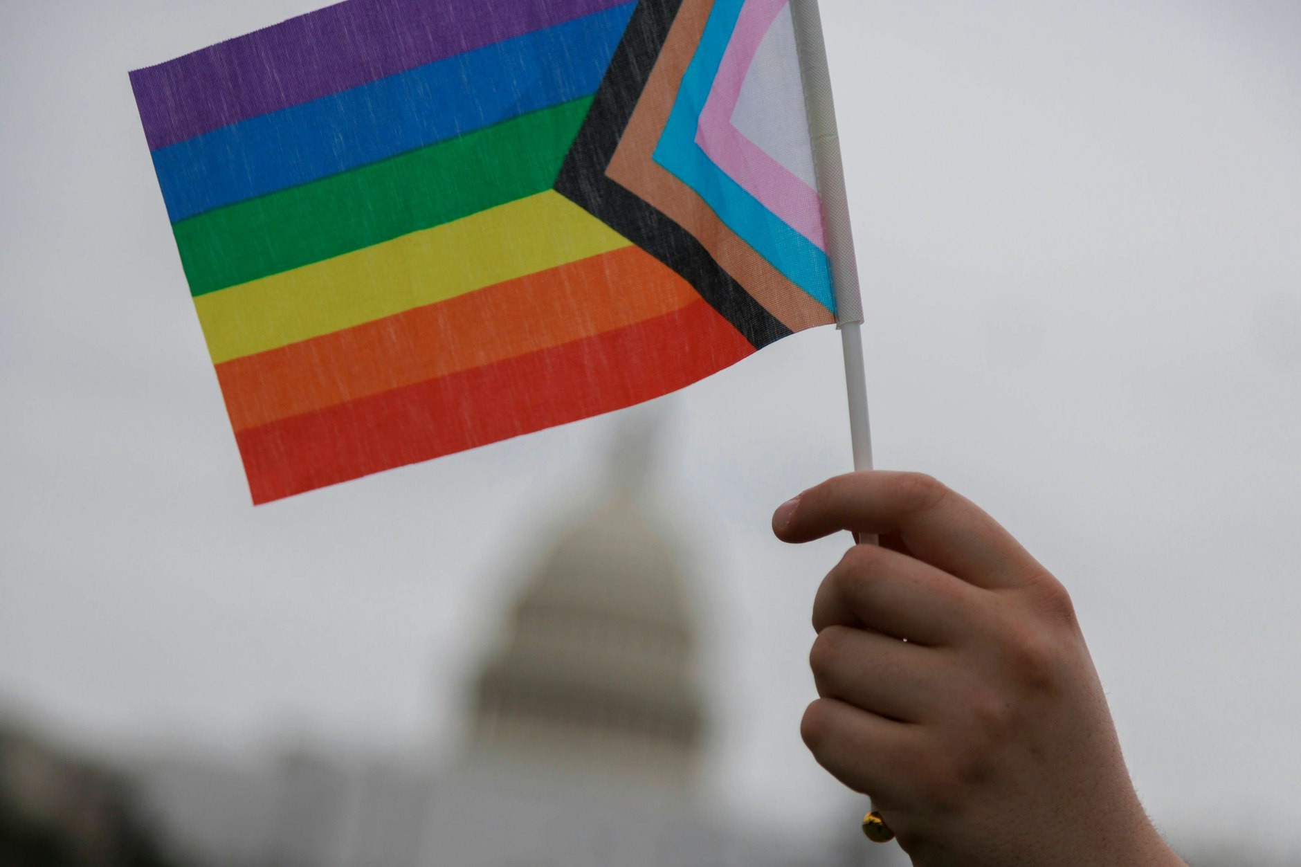 Eine LGBTQI+-Flagge wird hochgehalten.&nbsp;