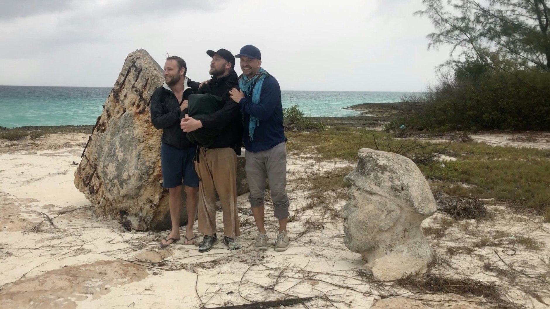 Das Drehteam auf der DDR-Insel: Hauptdarsteller Max Riemelt, Regisseur Ronald Vietz und Co-Kameramann Benjamin Raeder (v.l.) stehen zwischen den Resten des Thälmann-Denkmals, das ein Hurrikan zerstört hat.