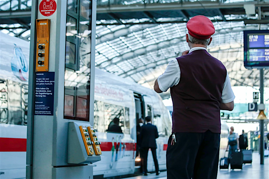 Ein Schaffner gibt ein Abfahrtszeichen für einen ICE auf dem Bahnsteig im Hauptbahnhof.&nbsp;