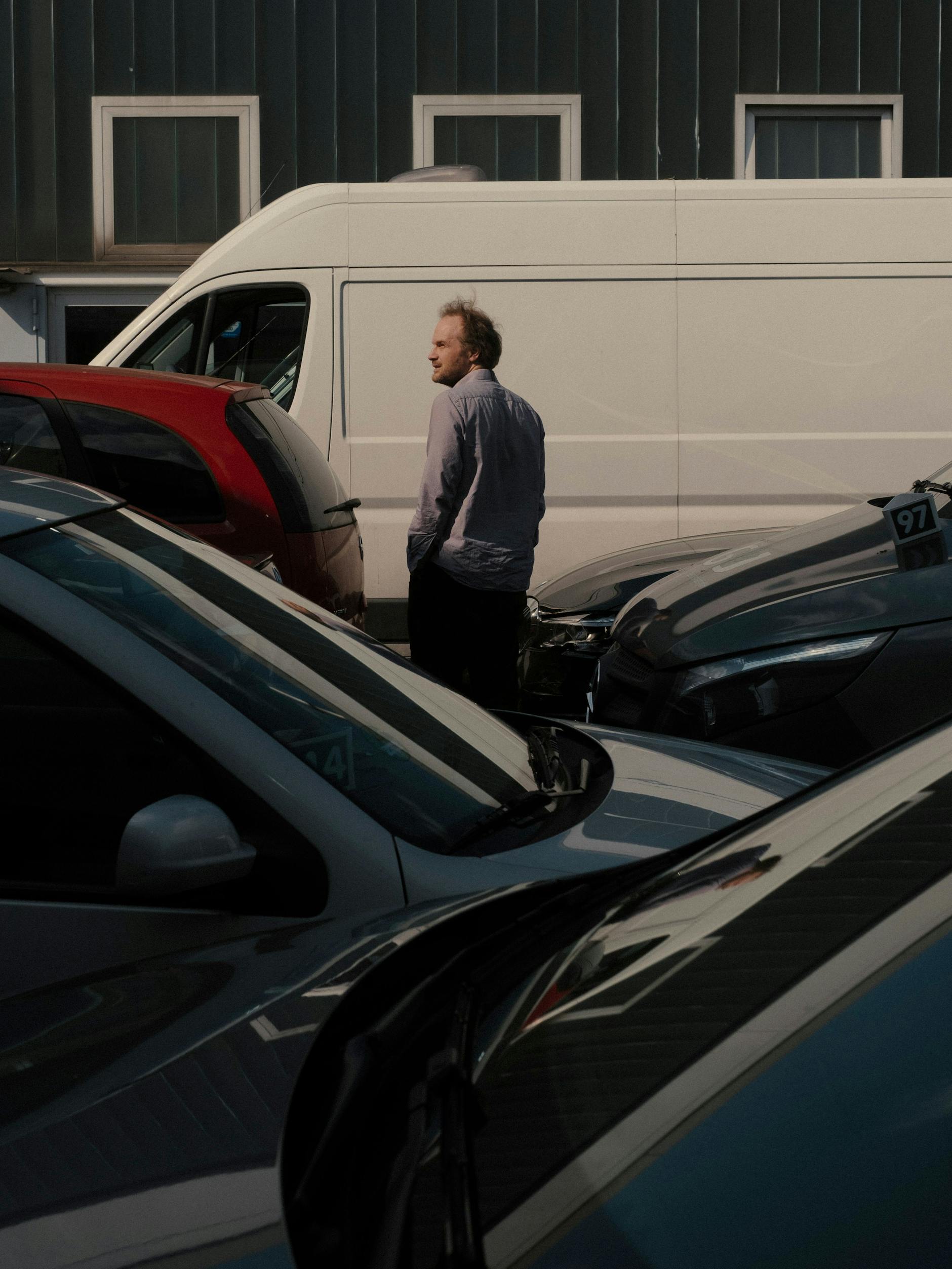 Conrad Kunze geht zwischen einigen Autos hindurch.