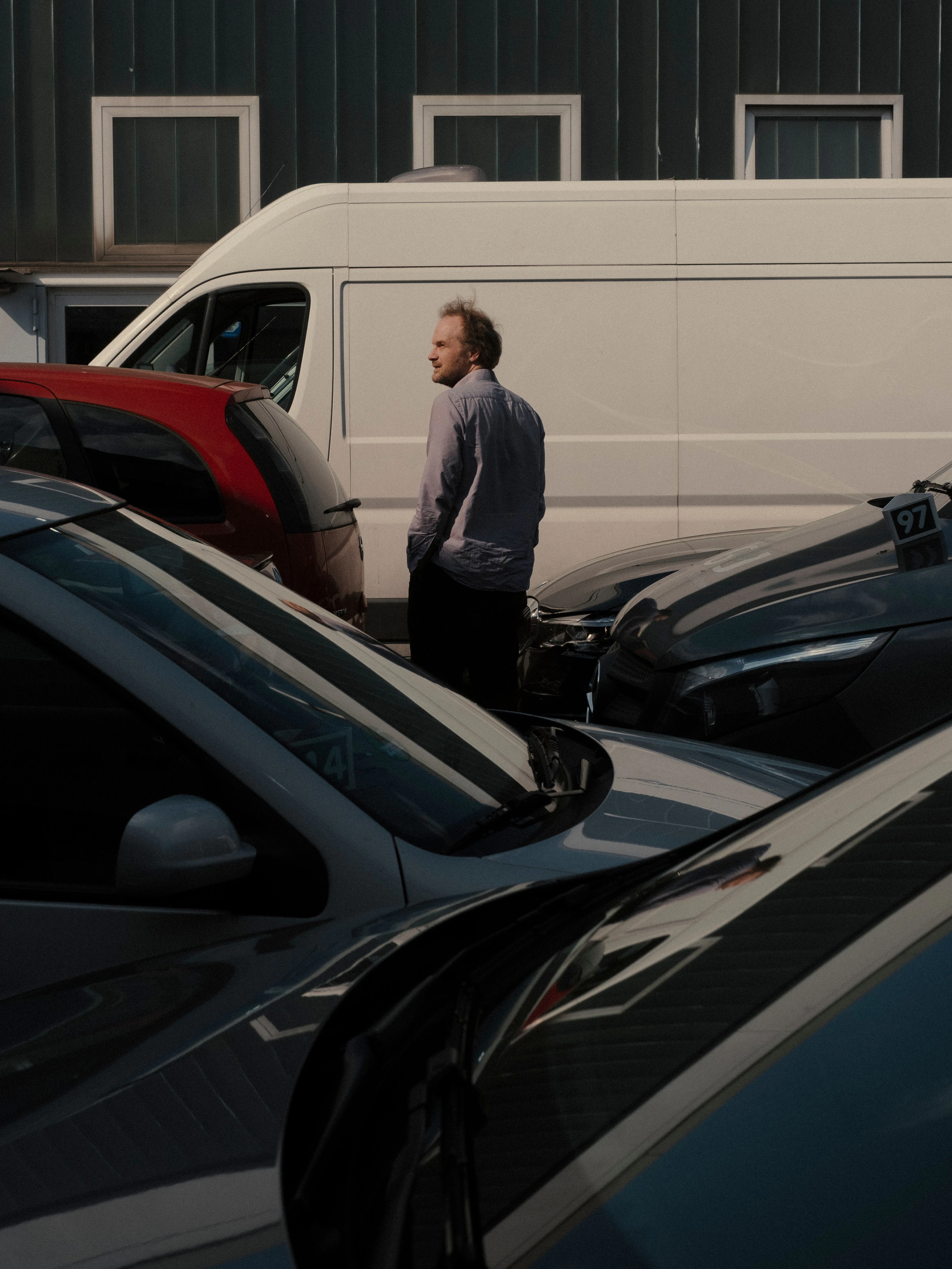 Conrad Kunze geht zwischen einigen Autos hindurch.
