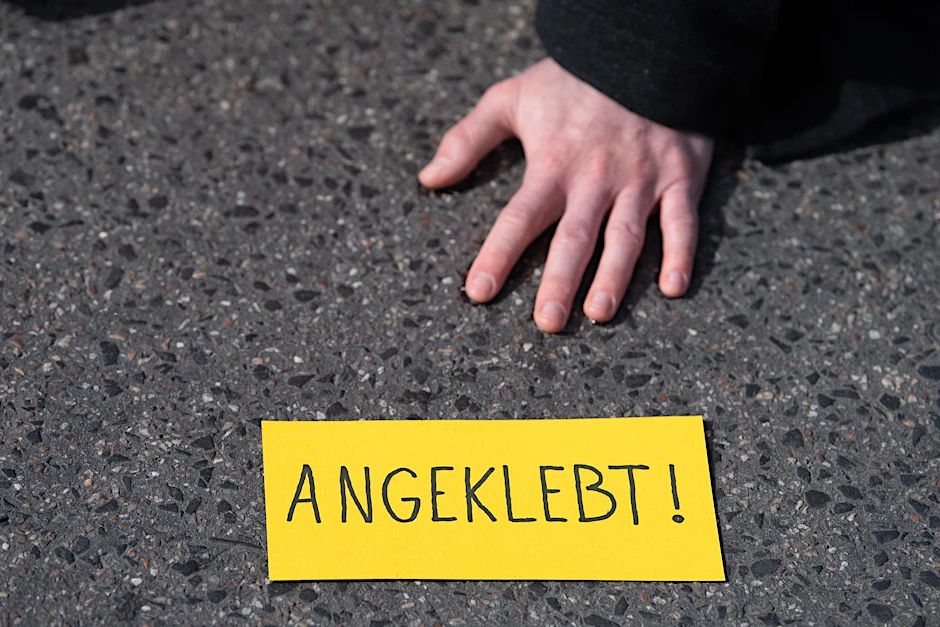 ARCHIV - Ein Demonstrant ist bei einem Protest der Gruppe «Letzte Generation» auf einer Straße festgeklebt.  