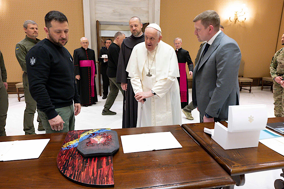Wolodymyr Selenskyj (li.) trifft im Vatikan Papst Franziskus. Auf dem Tisch liegt ein Kunstwerk aus einer kugelsicheren Platte, ein Geschenk von Selenskyj an Papst Franziskus.&nbsp;