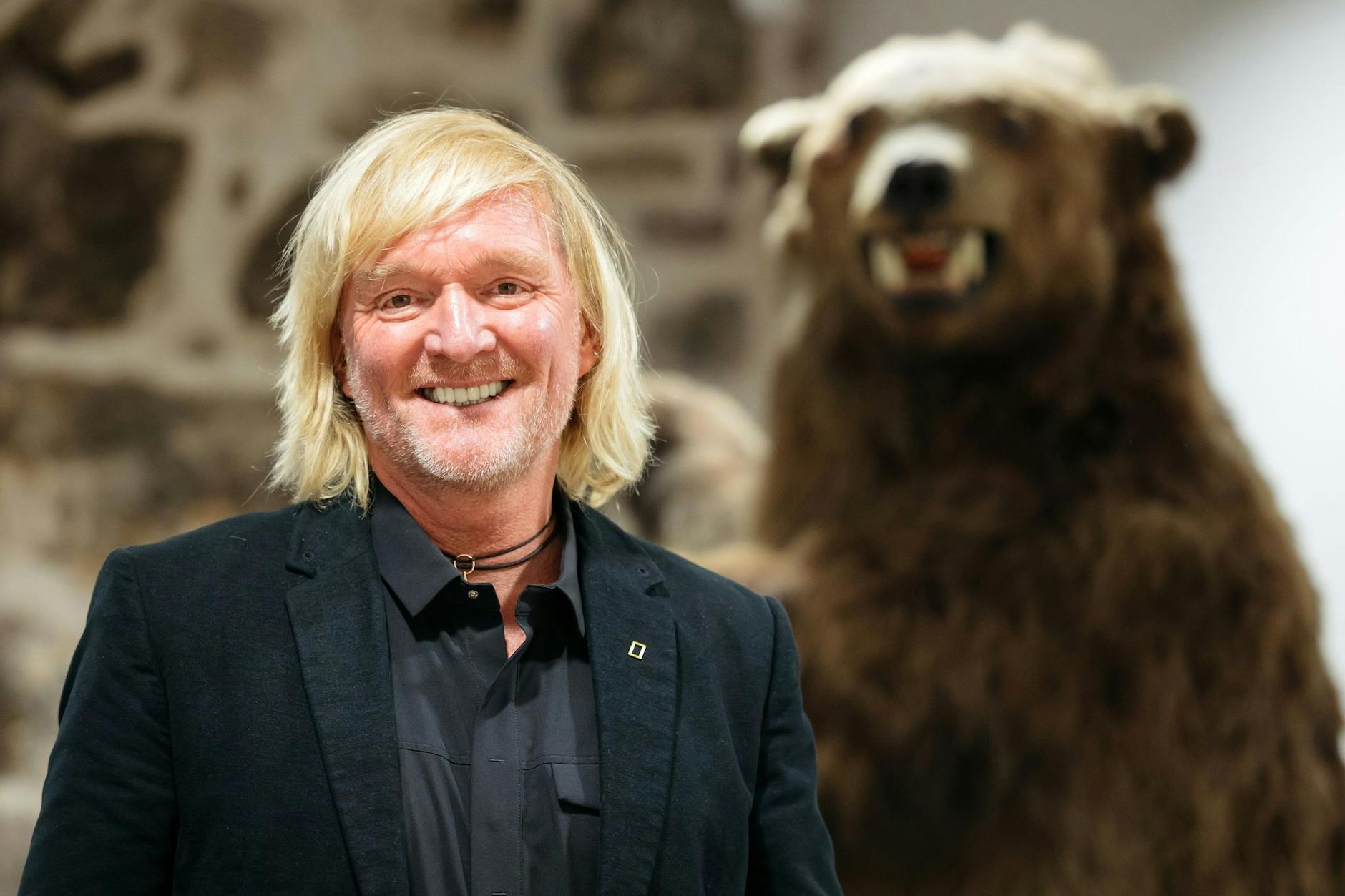Andreas Kieling bei der Vernissage zu seiner Ausstellung „Mit den Grizzlys durch Alaska“ neben einem Präparat eines Grizzlybären.