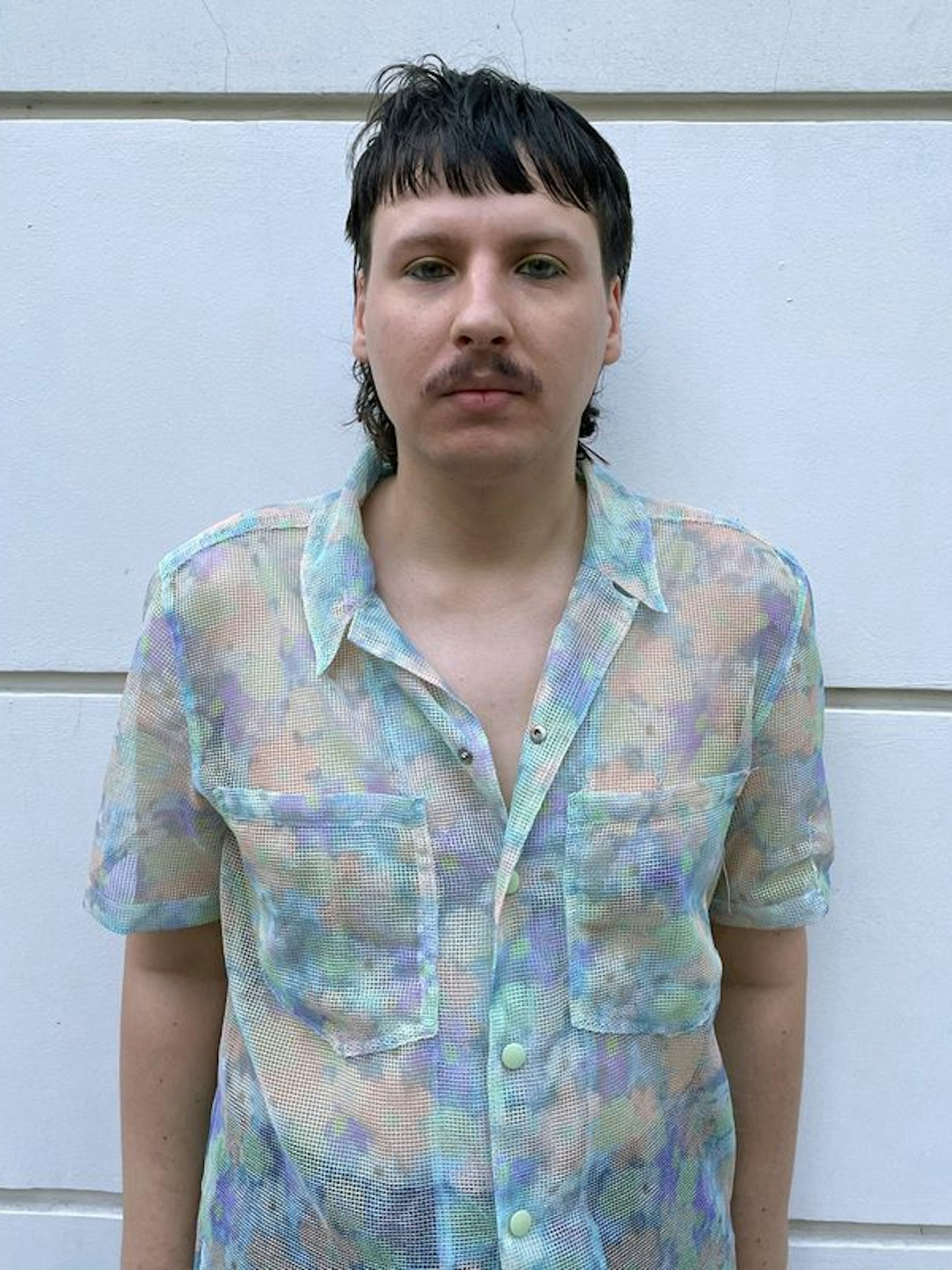 Niko Graczyk steht im Innenhof eines queeren Cafés. Der Warschauer ist nicht-binär und heute nicht mehr gläubig.