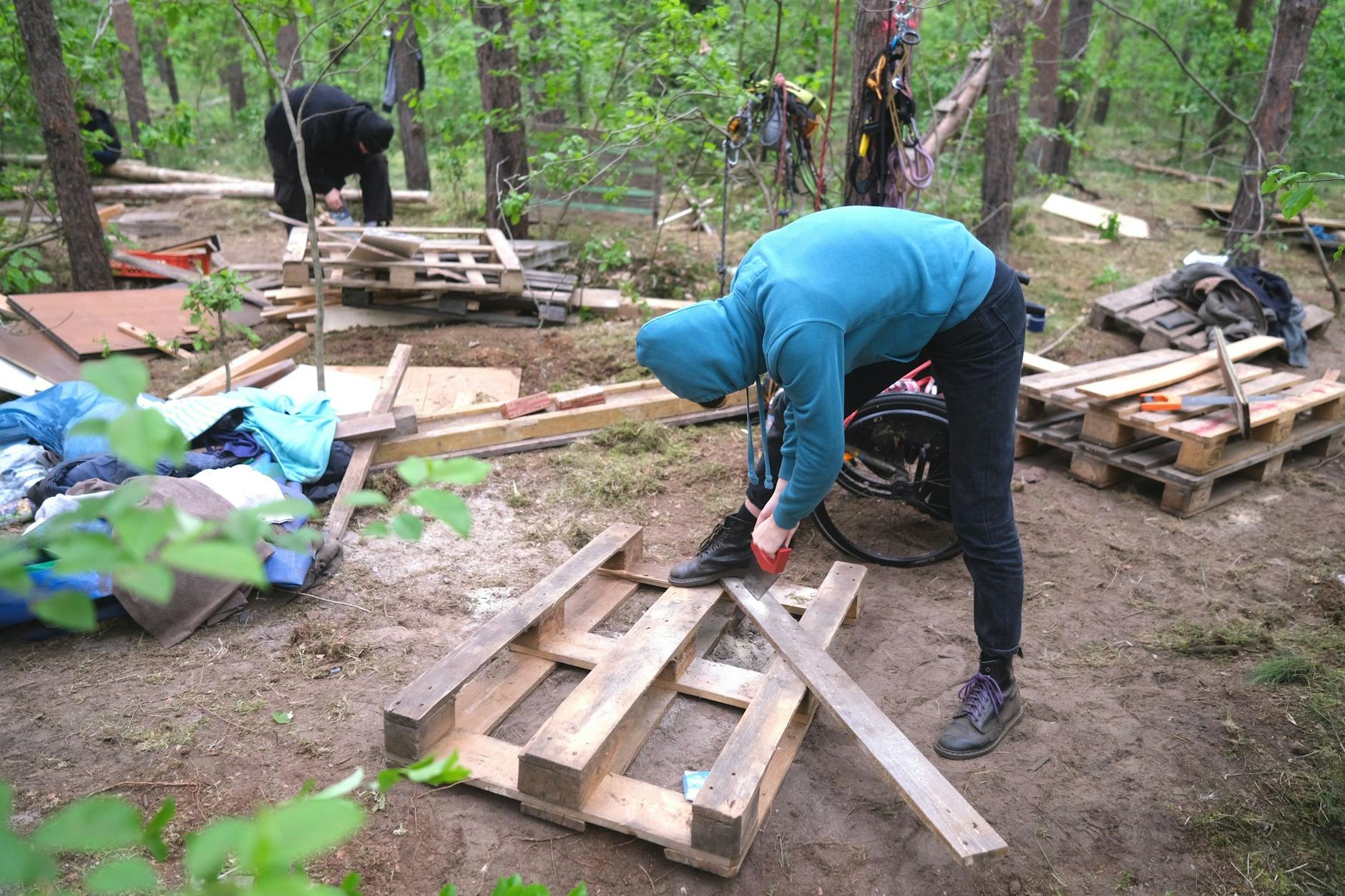 Ein Aktivist baut eine Plattform aus einer Palette. Am Wochenende waren fast 100 Umweltschützer zum Protest in der Wuhlheide.