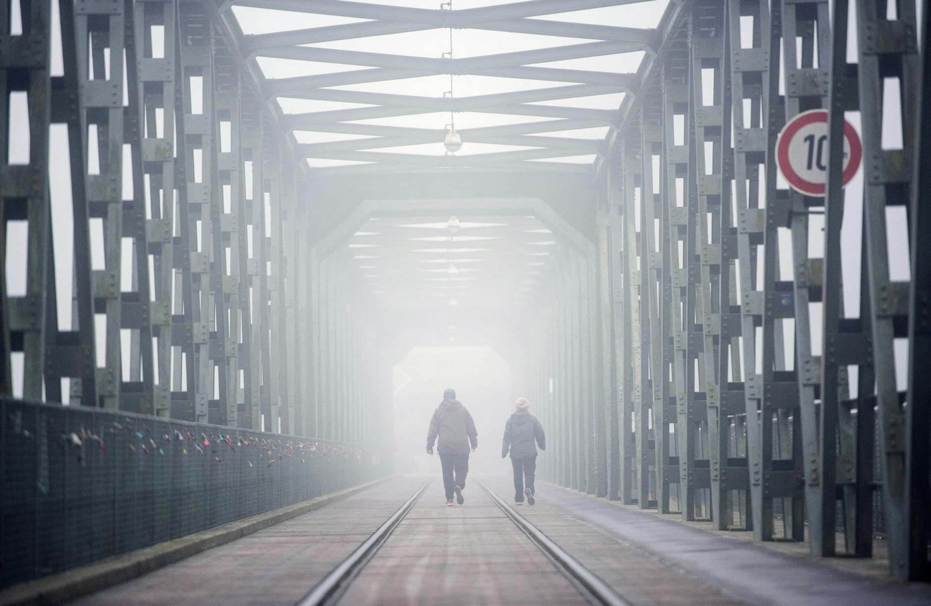 ARCHIV - Zwei Frauen gehen im Morgennebel über eine Brücke.  /dpa/Symbolbild