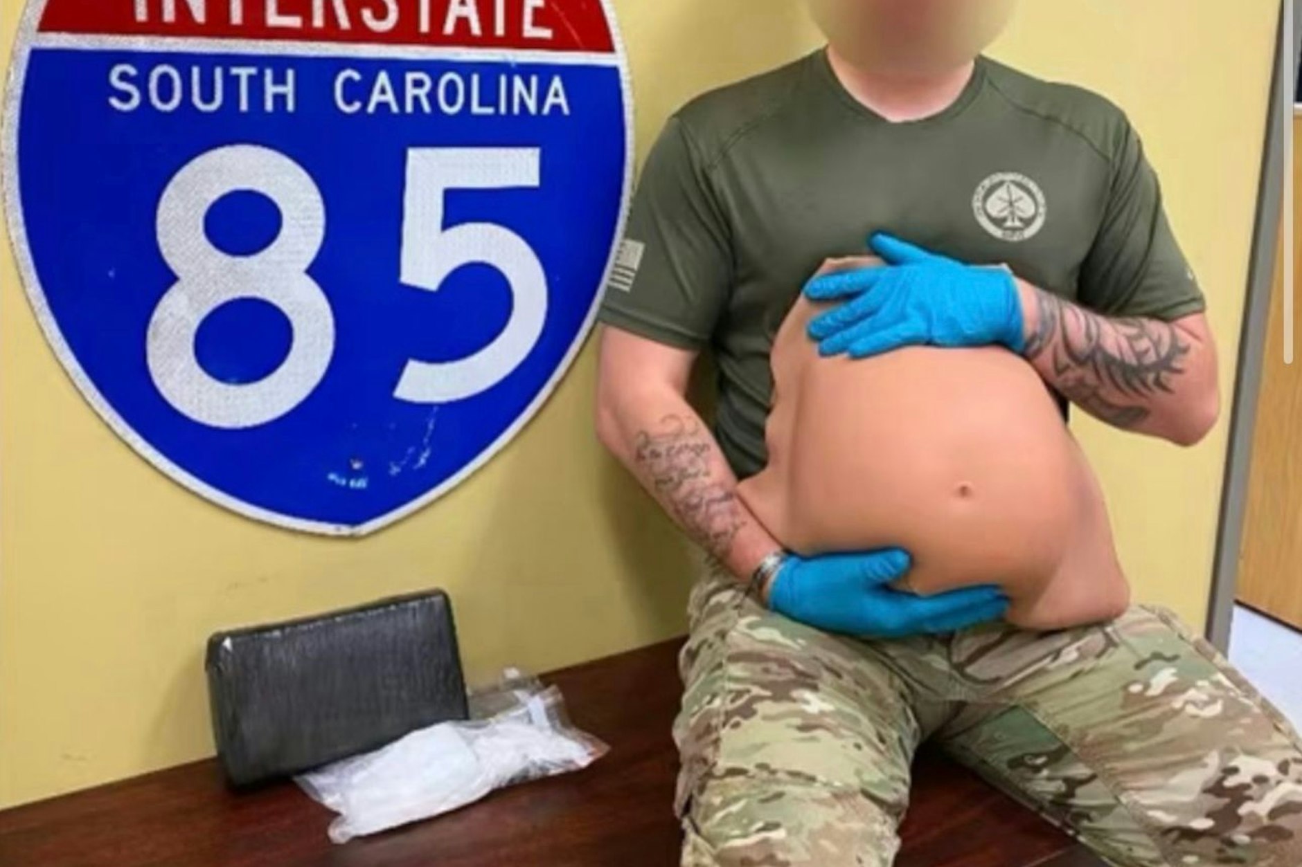 Ein Polizei-Offizier zeigt den Fake-Babybauch.