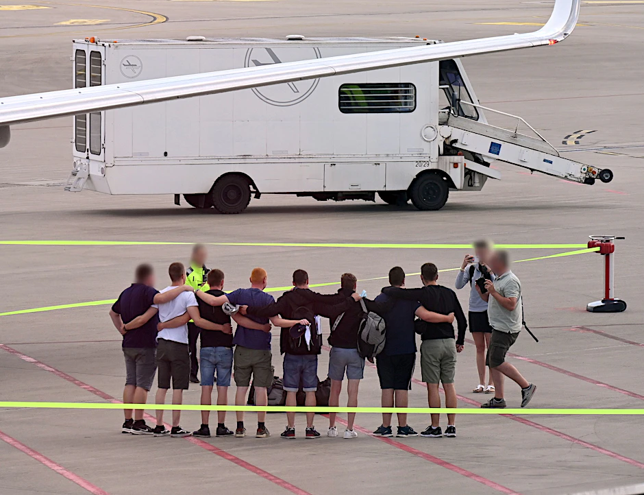 Münster: Die acht Männer, die auf Mallorca wegen Brandstiftung in Untersuchungshaft gesessen haben, stehen nach ihrer Ankunft in Deutschland auf dem Flughafen Münster-Osnabrück zusammen.