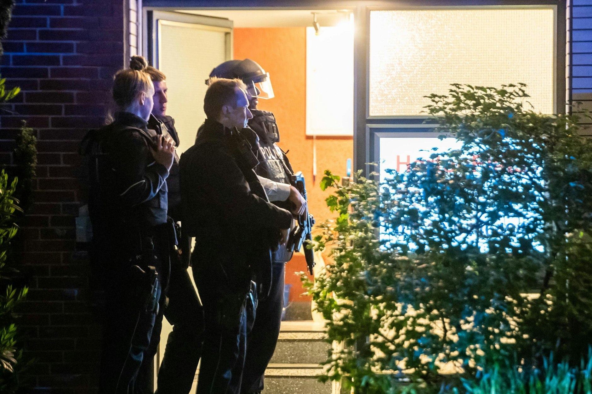 Bewaffnete Polizisten stehen an einer Haustür. Eine Mutter und ihre beiden Kinder sind tot in ihrer Wohnung im nordrhein-westfälischen Herten gefunden worden.