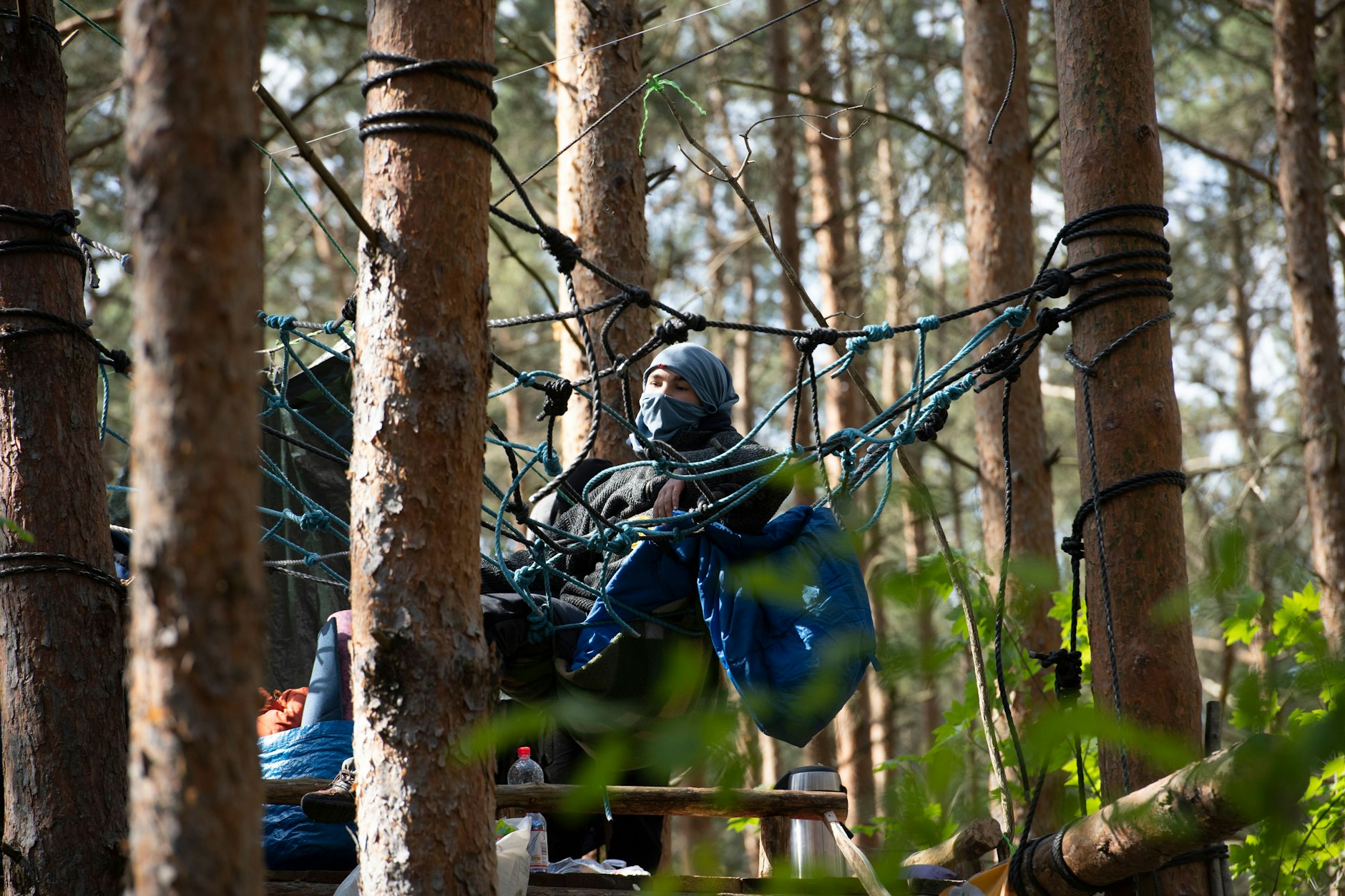 Ein Aktivistin sitzt in einem Waldstück in der Wuhlheide in einem illegal errichteten Baumhaus.