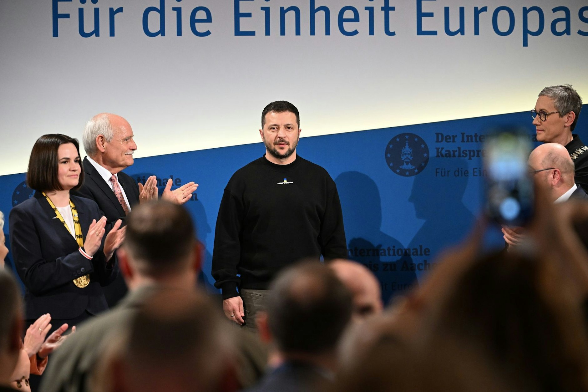 Der ukrainische Präsident Wolodymyr Selenskyj wird mit Applaus zur Preisverleihung in Aachen empfangen. 