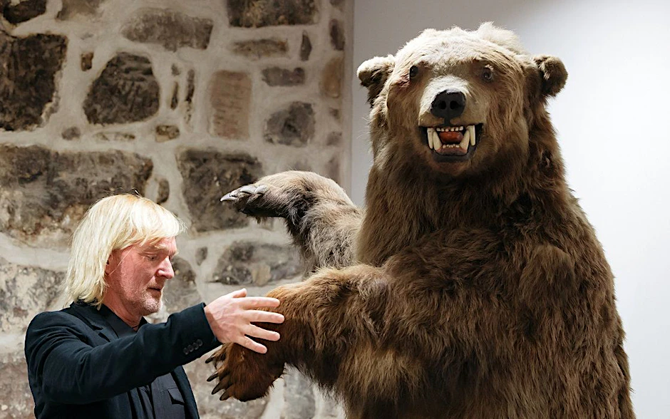 Andreas Kieling im Januar 2020 bei einer Vernissage neben dem Präparat eines Grizzlybären.&nbsp;