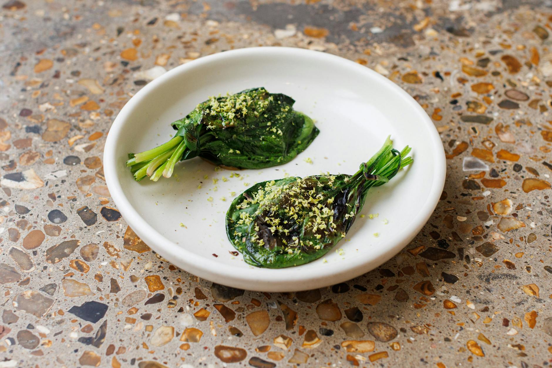 Spinatbündel mit Pistazien-Mole und gerösteten Pistazien.