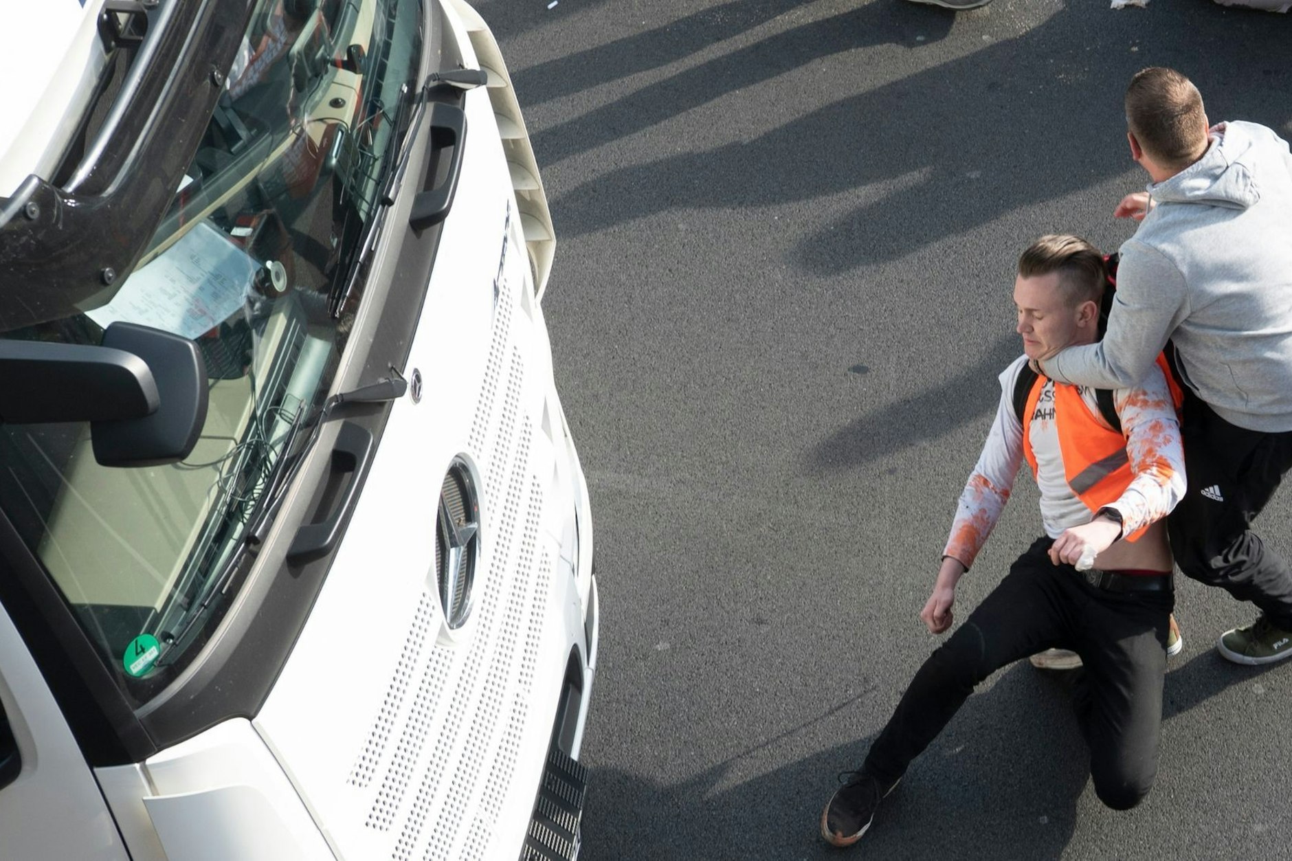 Nachdem die Klimaschutzgruppe Letzte Generation die Stadtautobahn A100 in Berlin blockiert hat, platzt einem Mann der Kragen - im Würgegriff zerrt er einen der Aktivisten mit Gewalt von der Straße.
