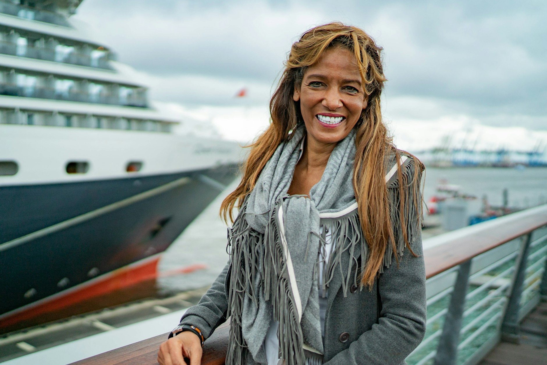 Nadja Abd el Farrag posiert im Hamburger Hafen. Im Hintergrund das Kreuzfahrtschiff Queen Victoria.