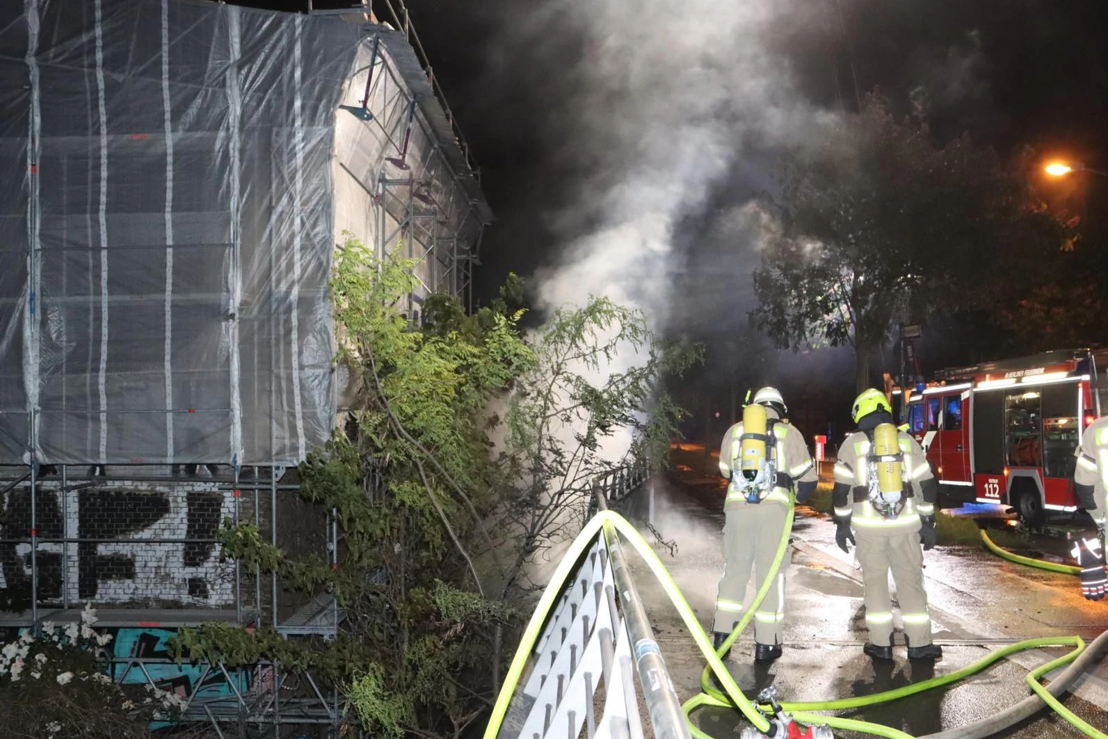 Feuer unter der Modersohnbrücke: Feuerwehrkräfte verhindern, dass die Flammen auf anliegende Gebäude  überspringen.