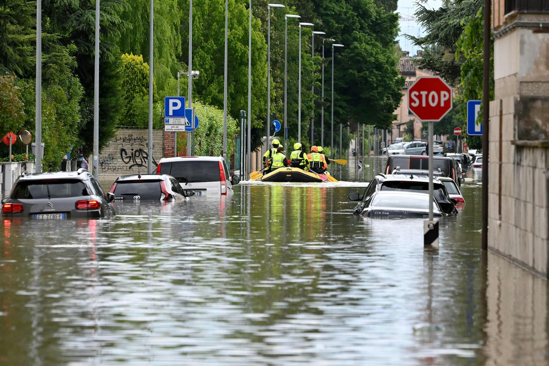 Italienische Rettungskräfte evakuieren Bewohner in einem Schlauchboot über eine überflutete Straße in der Ortschaft Lugo, in der Region Emilia Romagna.