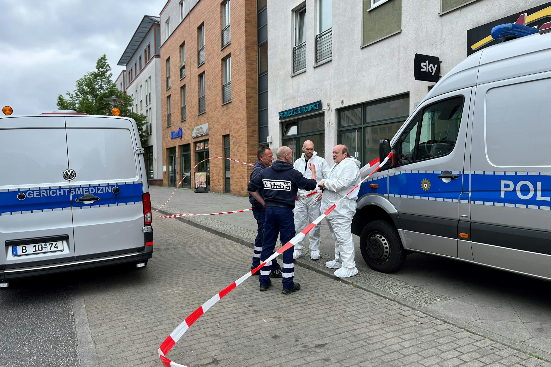 Gerichtsmediziner stehen vor dem Tatort im Berliner Stadtteil Hellersdorf.